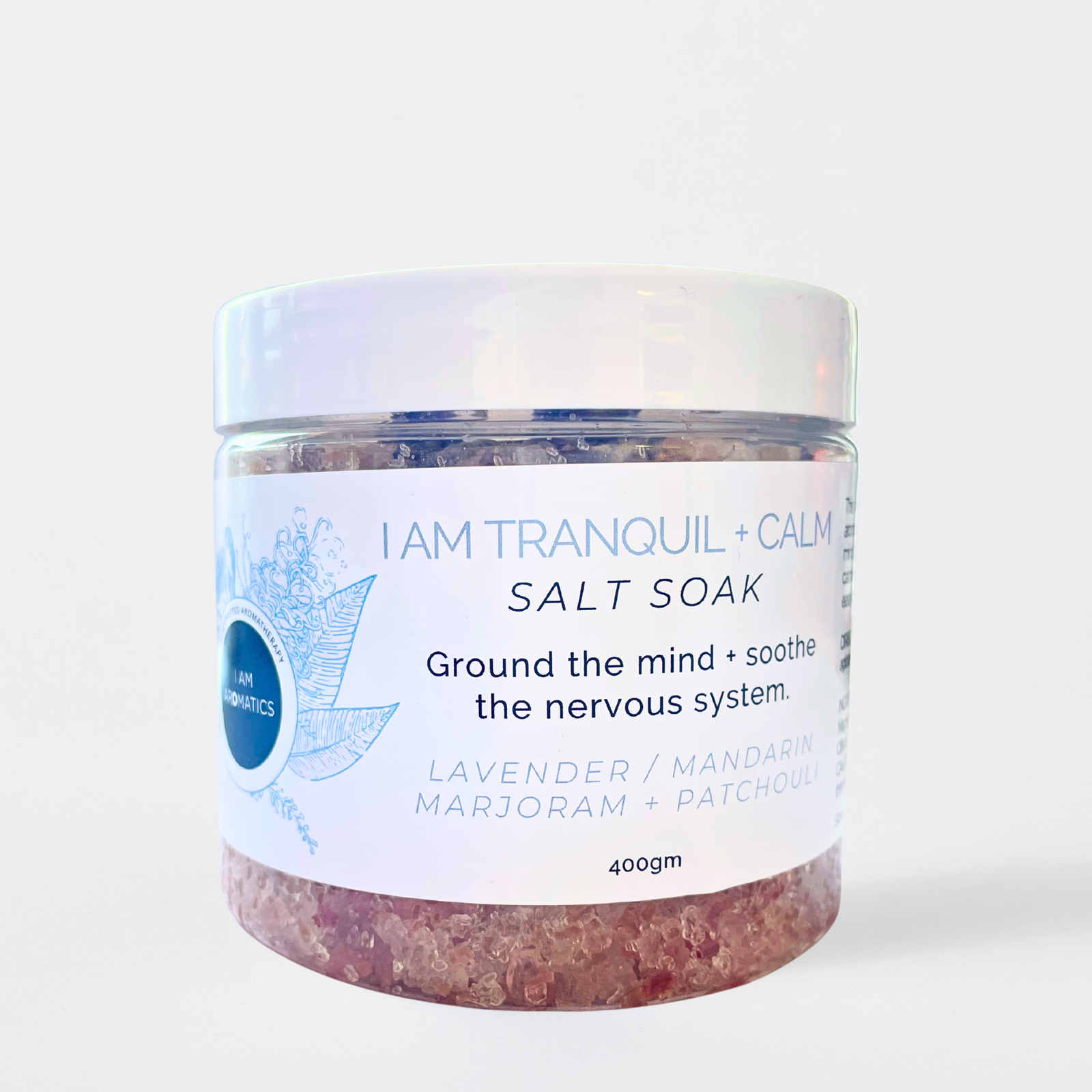 Jar of 'I Am Tranquil + Calm' salt soak with a white label on a light blue background