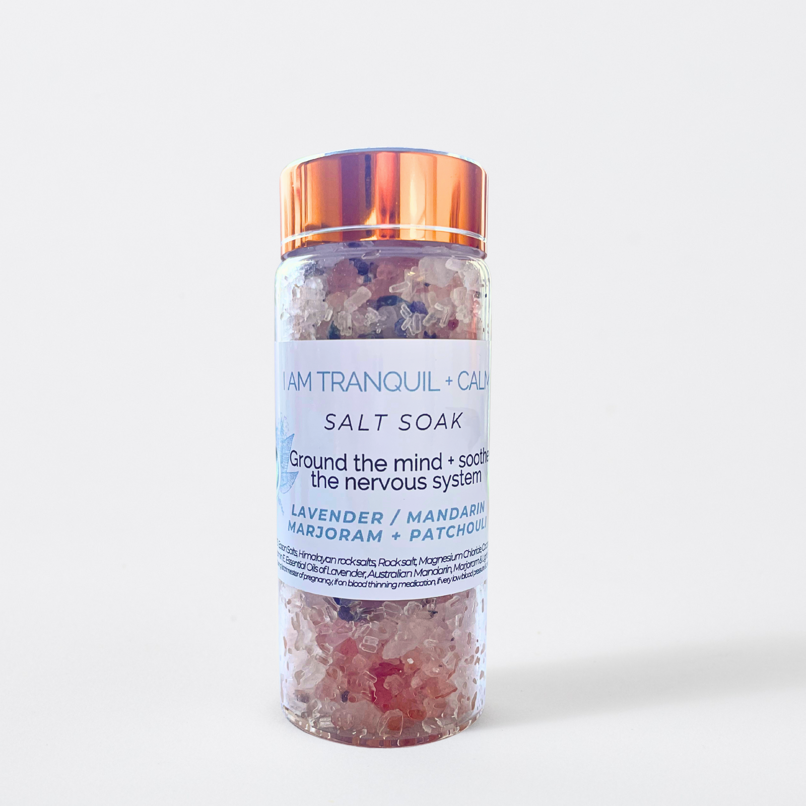 Jar of 'I Am Tranquil + Calm' salt soak with a white label on a light blue background