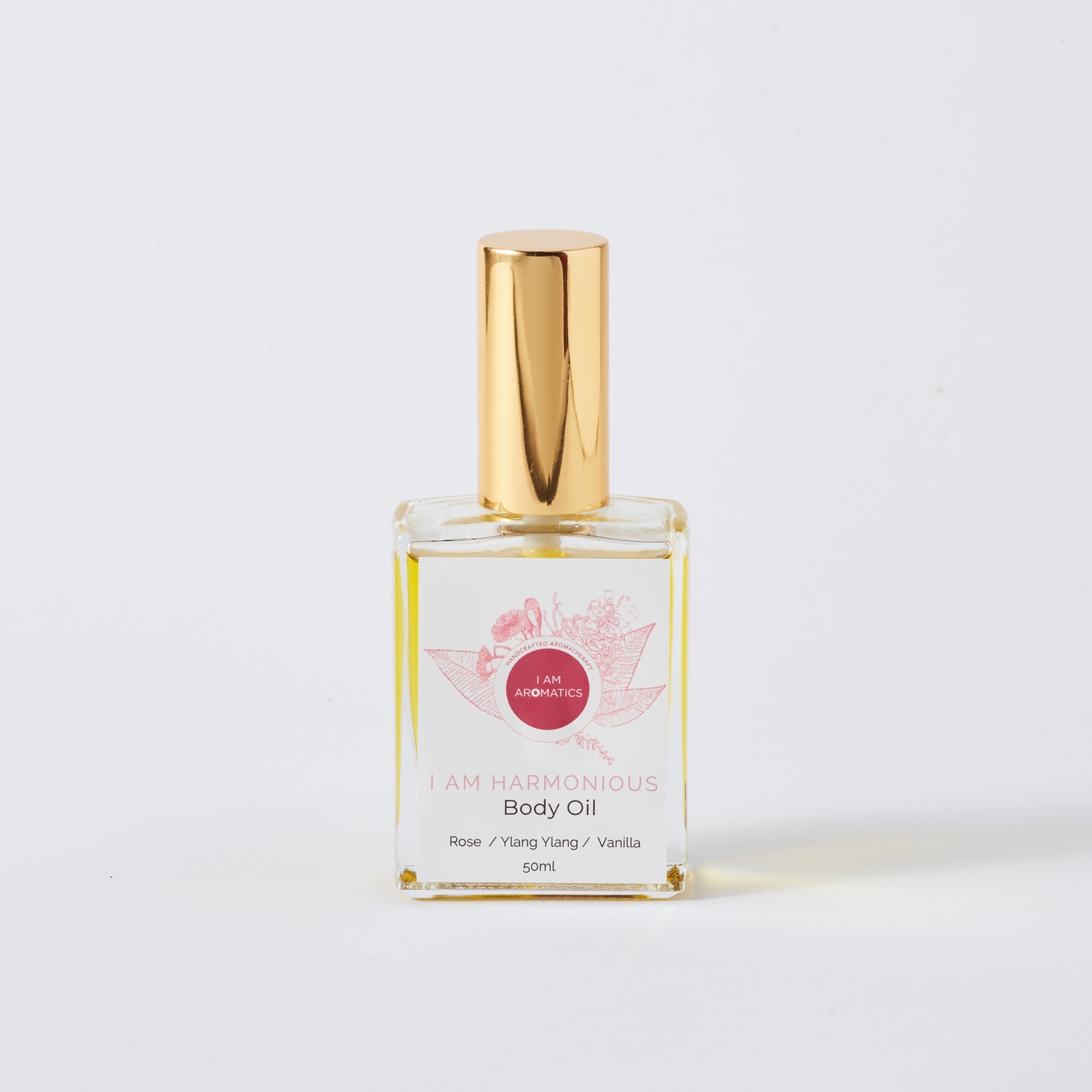 harmonious 50ml body oil, clear glass rectangle bottle with gold atomiser, pink botanical logo and pink font