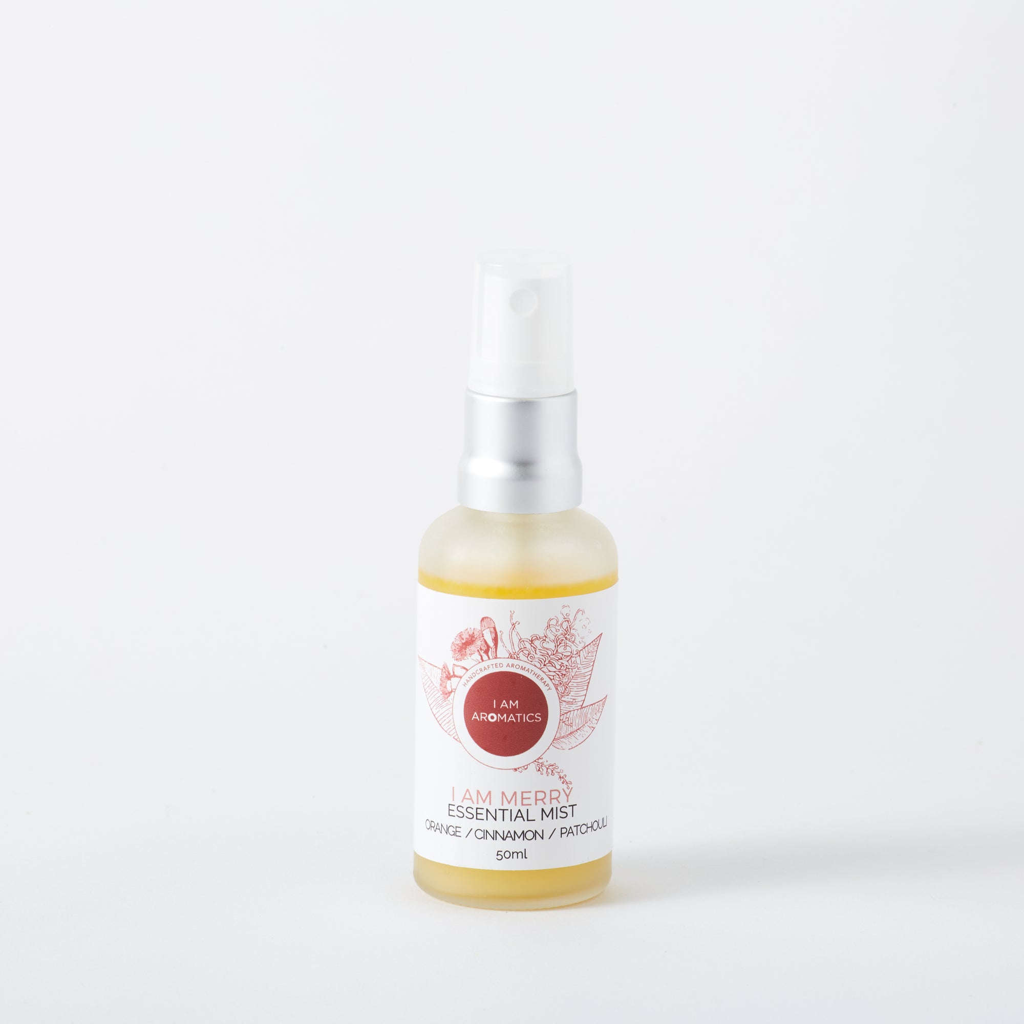 Merry essential mist, frosted glass bottle with yellowish liquid inside, matt silver atomiser, white label with deep red botanical logo and font