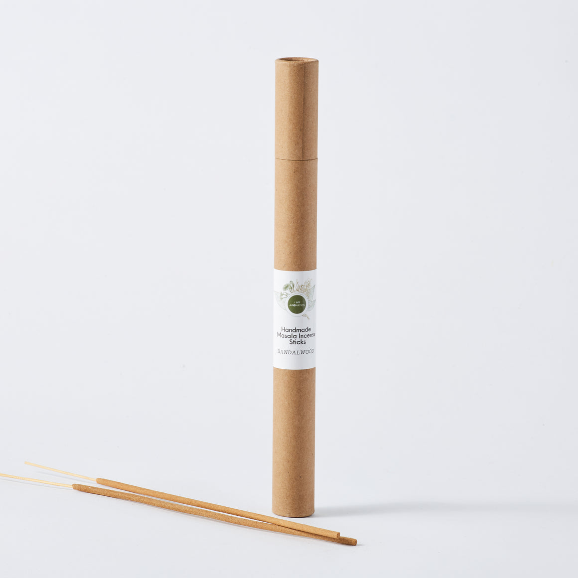 kraft brown paper container standing tall with white label and botanical logo. two sticks of incense laying beside