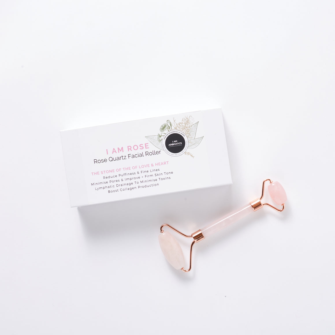 white packaging rectangle box with lablel botanical logo, black and pink font. Rose qartz facial roller laying flat